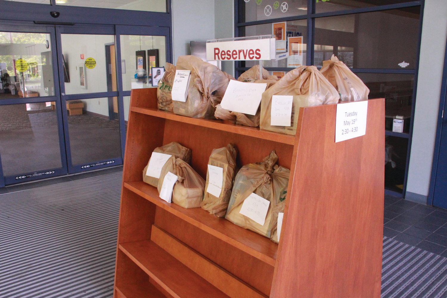 READY FOR PICKUP: Books and other materials are bagged with the name of the recipient waiting for pickup just inside the main doorway to the Warwick Public Library.
