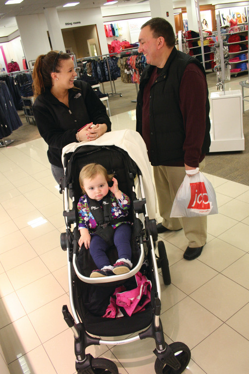 RENEWING ACQUAINTANCES: Courtney Peltier and Larry Lopes, friends for many years, crossed paths while shopping yesterday at J. C. Penney. Peltier was sitting Kaelyn Quinn who went along for the ride.