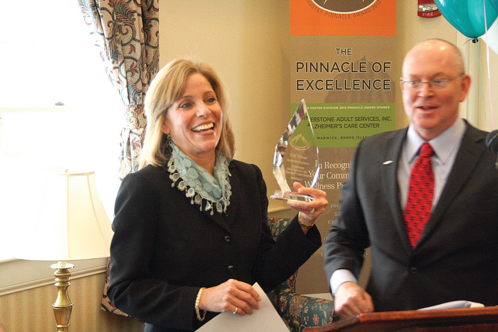 AT THE TOP: Cornerstone Adult Services Administrator Dottie Santagata holds the Pinnacle Award aloft as NuStep’s Steve Sarns looks on during yesterday’s ceremony.