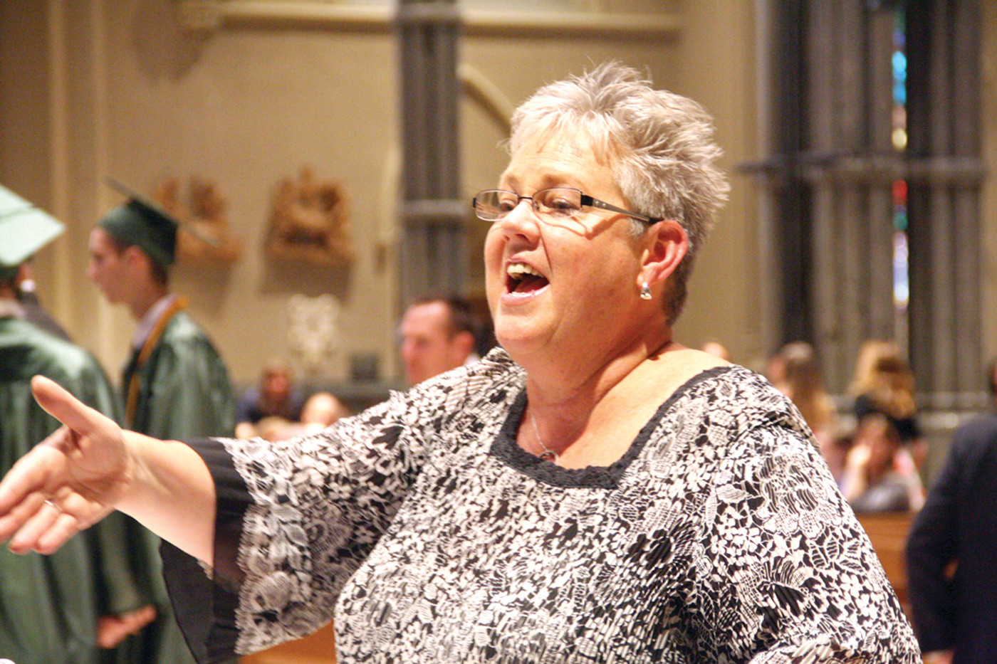 LIFTING THEIR VOICES: Mary Jo Gambardella directs the chorus in a selection prior to the start of the ceremony.