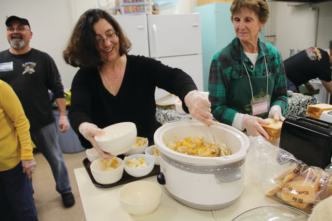DISHING OUT DESSERT: Sherry Bailey fills bowls with peach cobbler as Santina Mulligan takes a break from making BLT sandwiches to look on.