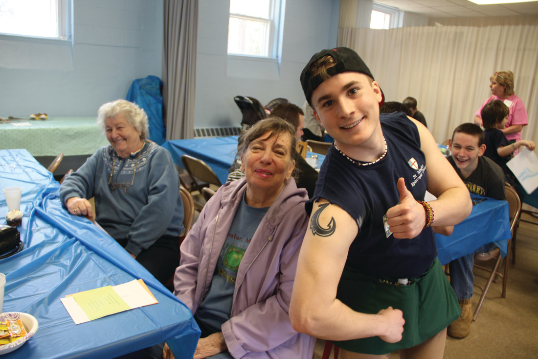 THEY’RE HOOKED: Mary Miller and Beth Roberts share a laugh with URI student and volunteer Jacob McNamara, who was delighted to show off his tattoo.