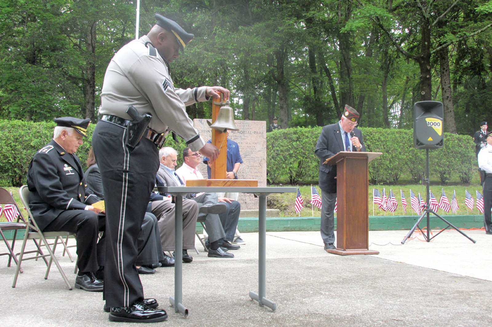 DOUBLE DUTY: With Lt. Col. Gary W. Maddocks Sr., US Army Retired reading the names of Johnston natives who were killed in various wars, JPD Sgt. Dennis Peacock, US Marine Corps. Retired, rings the bell in honor of each deceased veteran.