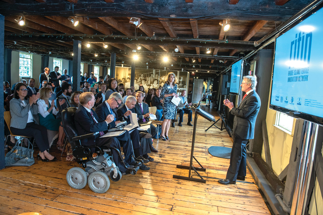 A NEW IMAGE: Michael Woody, CEO of Trans-Tex, LLC in Cranston and President of the Rhode Island Textile Innovation Network, addresses a crowd of more than 100, including the Congressional Delegation, textile manufacturers, designers, university faculty and government officials.