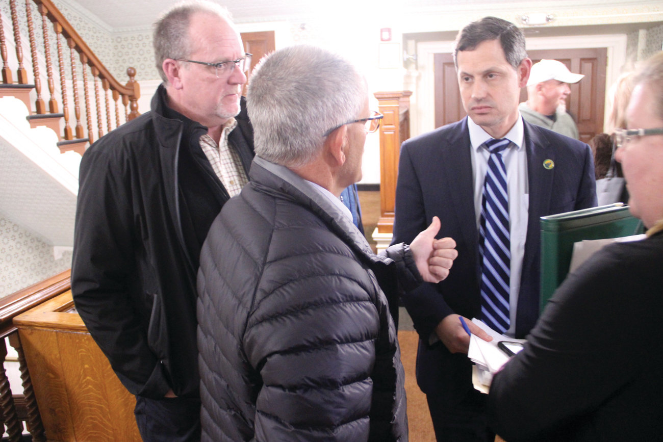 LOTS OF QUESTIONS: AFSCME Council 94 lobbyist and senior staff representative Jim Cenerini talks with Peter Ginaitt, a former state representative and retired Warwick firefighter, and retired Department of Public Works director David Picozzi during Monday’s council meeting.