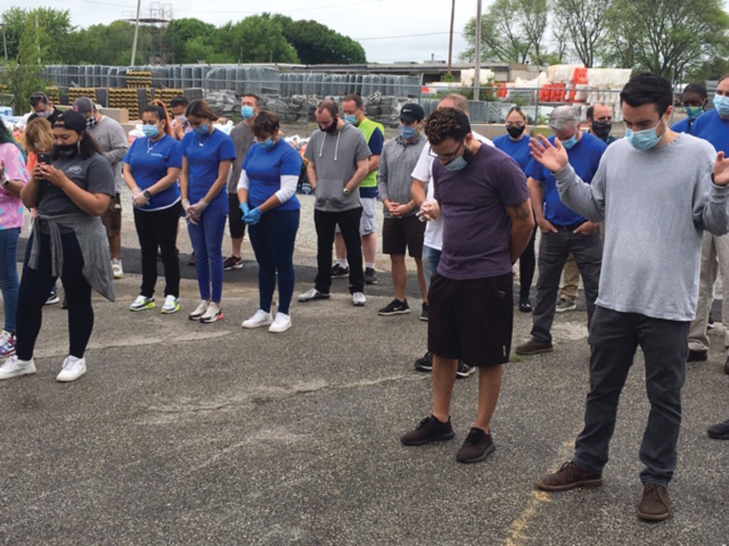 JOINED IN PRAYER: Representatives from Feed the Children, Price Rite Marketplace and members of Legacy Church pause to give thanks following the formal kickoff of the food distribution Thursday from a Warwick warehouse. 