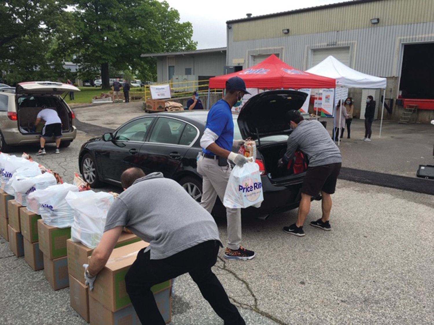 PACKING IT IN: Volunteers help load boxes and bags of food and other supplies into the vehicles of those who had obtained vouchers on line. 