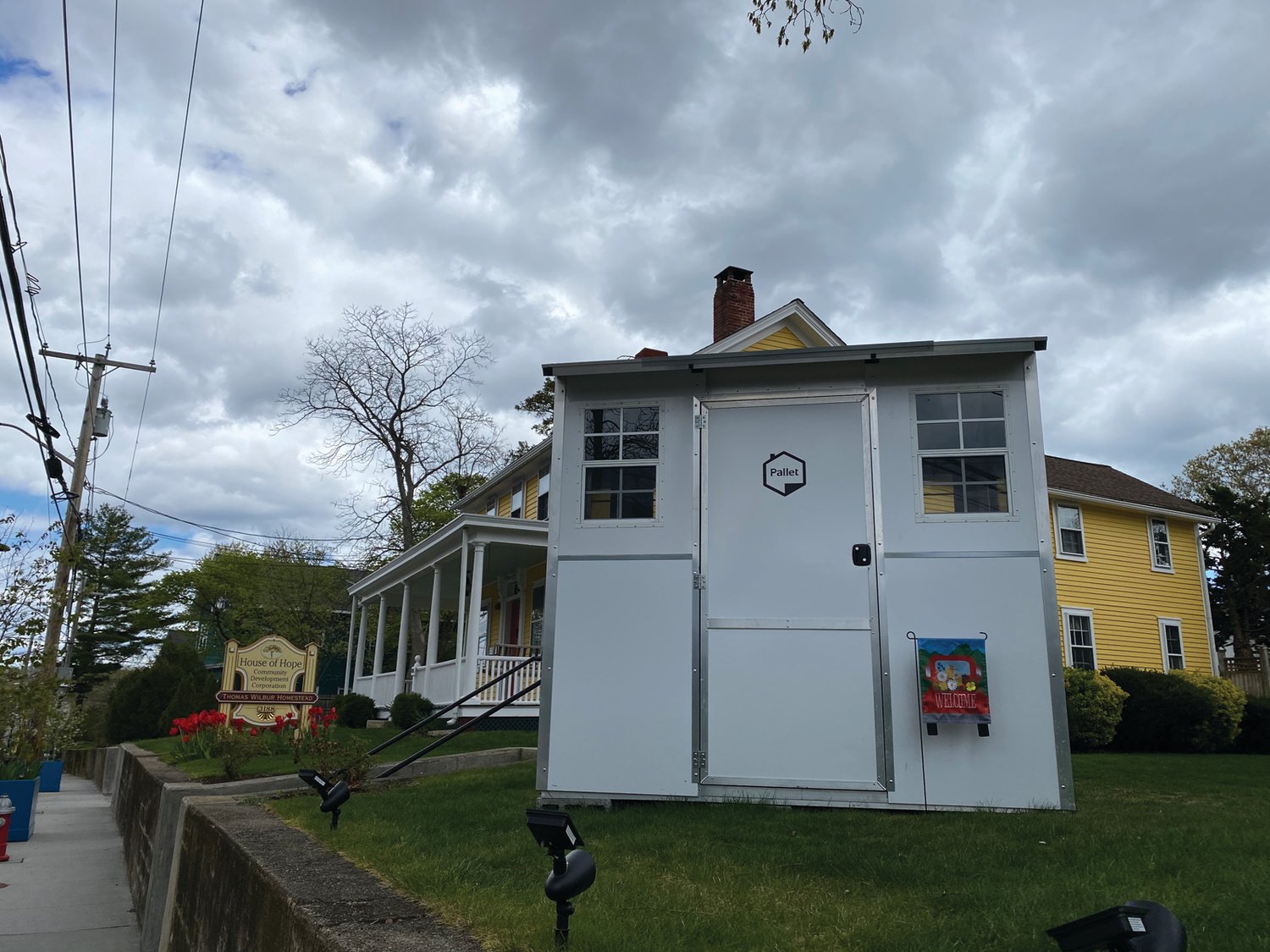 AFFORDABLE HOUSING: A Pallet temporary shelter sits on the front lawn of House of Hope in Warwick. While it may not have all the bells and whistles of the Rohe homes, this tiny home is a step in the right direction for RI’s homeless.