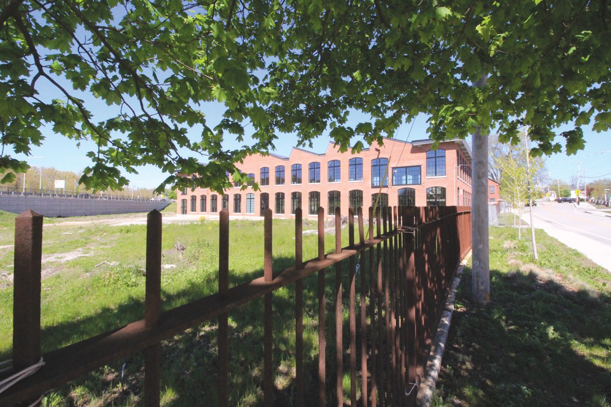 VILLAGE GATEWAY: The Sawtooth Building, the lone remaining structure of the once thriving Apponaug Mill complex that is owned and been rehabilitated by AAA Northeast, is being considered as a new central home for municipal offices.