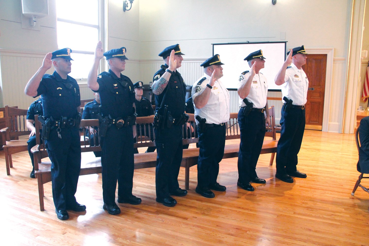 OATH OF OFFICE: With raised hands, those officers being promoted repeat the oath as read to them by Mayor Frank Picozzi.