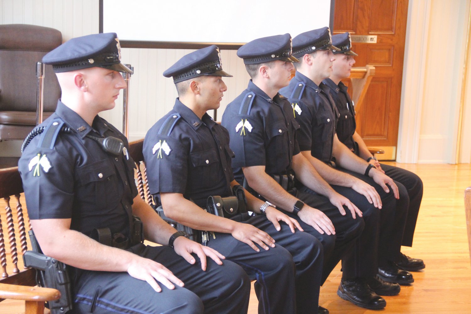 NEW TO THE FORCE: Probationary officers await to be individually recognized and called before the audience and receive their badges as Warwick Police officers.