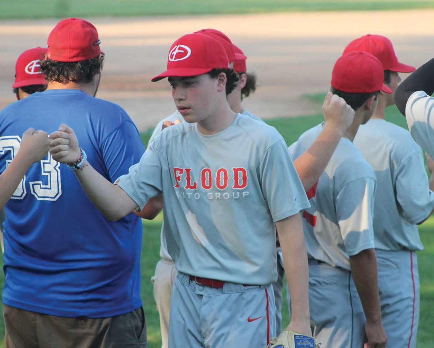PLAYOFF BASEBALL: Members of Flood Ford fist
bump after an inning.