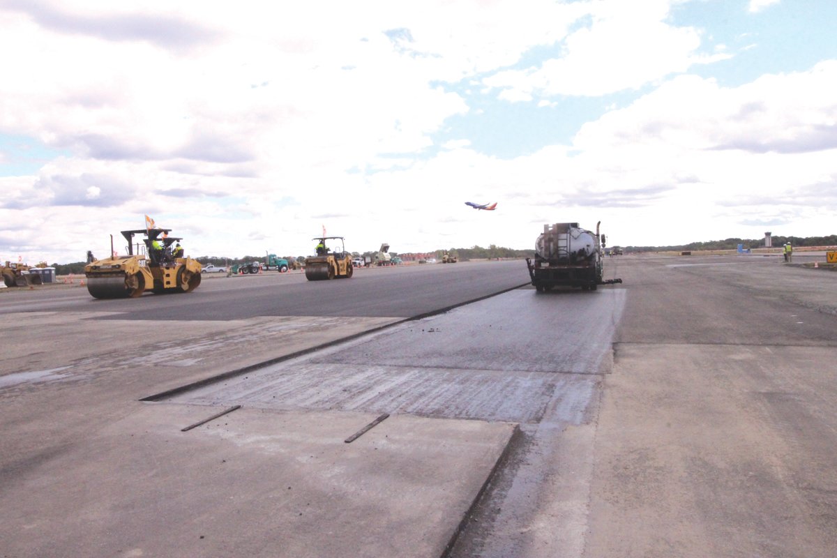 WIDE OPEN SPACES: The shear length and width of the runway becomes all the more apparent as the paving crew applies a layer of hot asphalt.