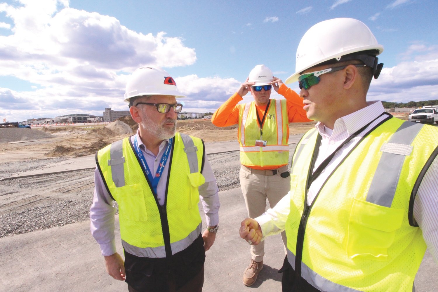 KEEPING TABS ON THE JOB:  Jeff Wiggin, Mark Noonan and Duc Nguyen during a recent tour of the reconstruction of Runway 16-34.