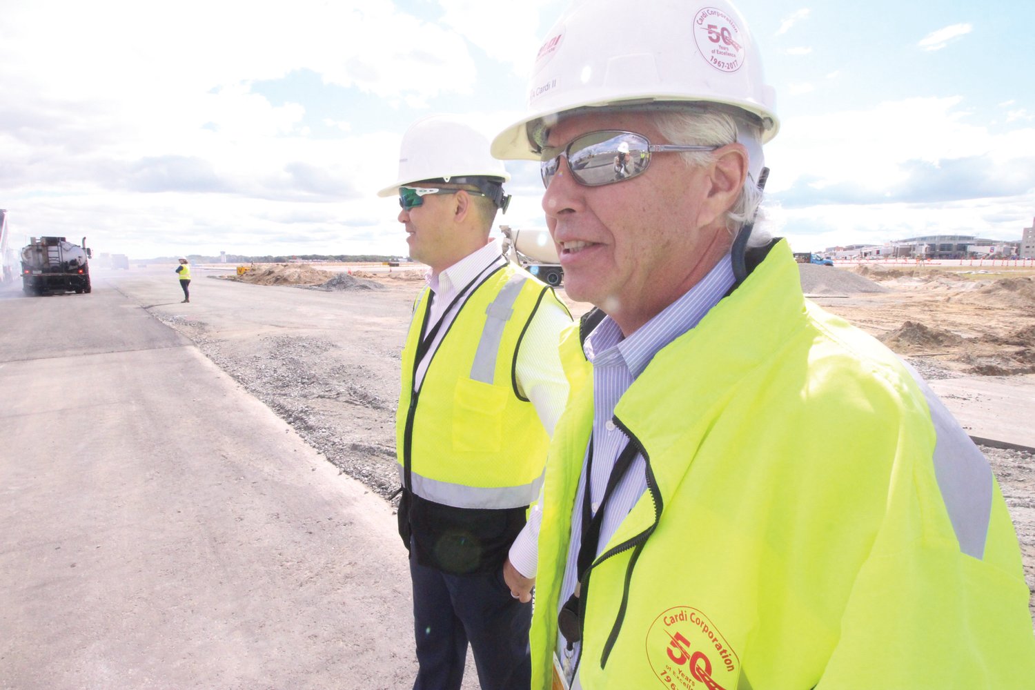 THE BOSS IS CHECKING IT OUT: Stephen Cardi II, right, and Duc Nguyen survey progress on the reconstruction of Runway 16-34.