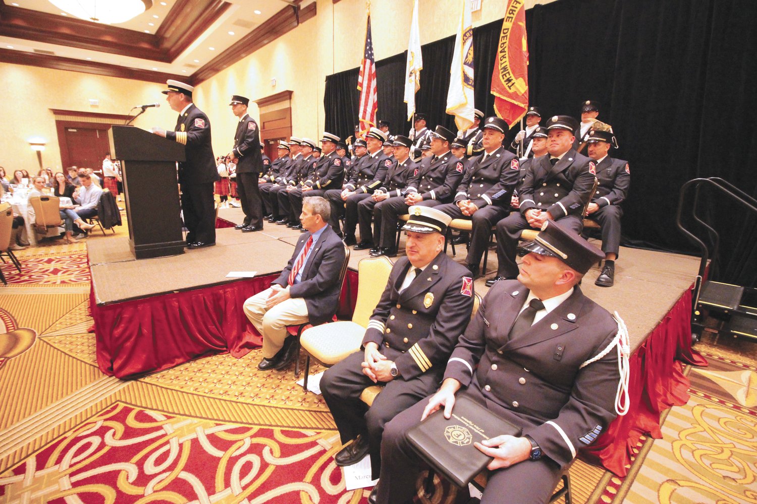 PRELUDE TO PROMOTIONS: Fire Chief Peter McMichael addresses the audience assembled at the Crowne Plaza ballroom for promotional ceremonies last Wednesday.