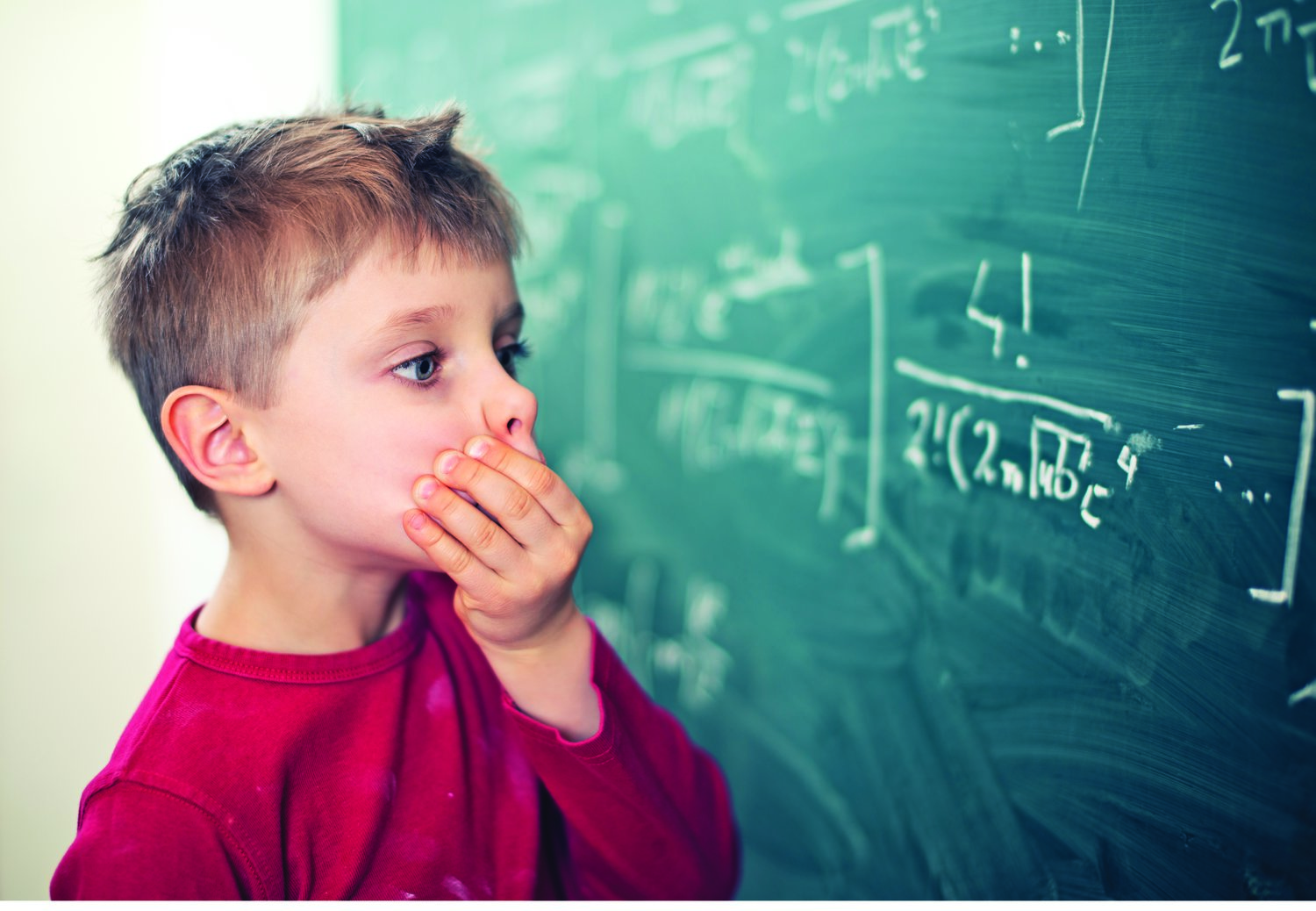 Little boy aged 5 in math class overwhelmed by the math formula.