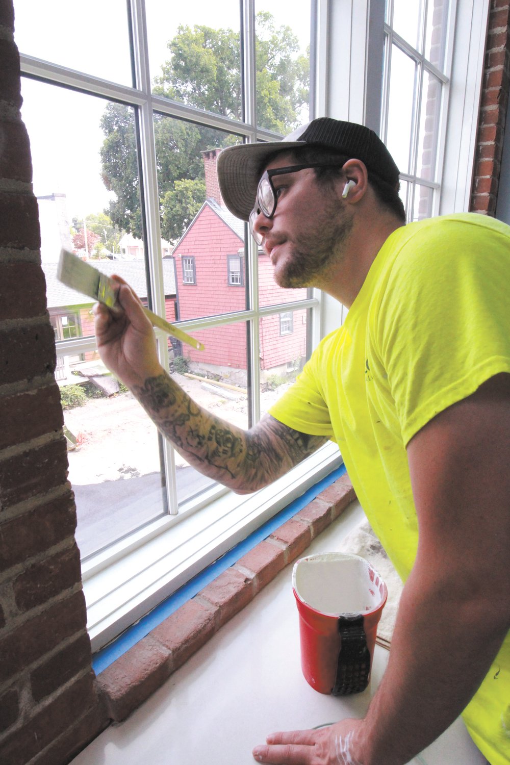 TOUCH UP: Jared Anderson of Coastal Glazing gives a window frame a final coat of paint.