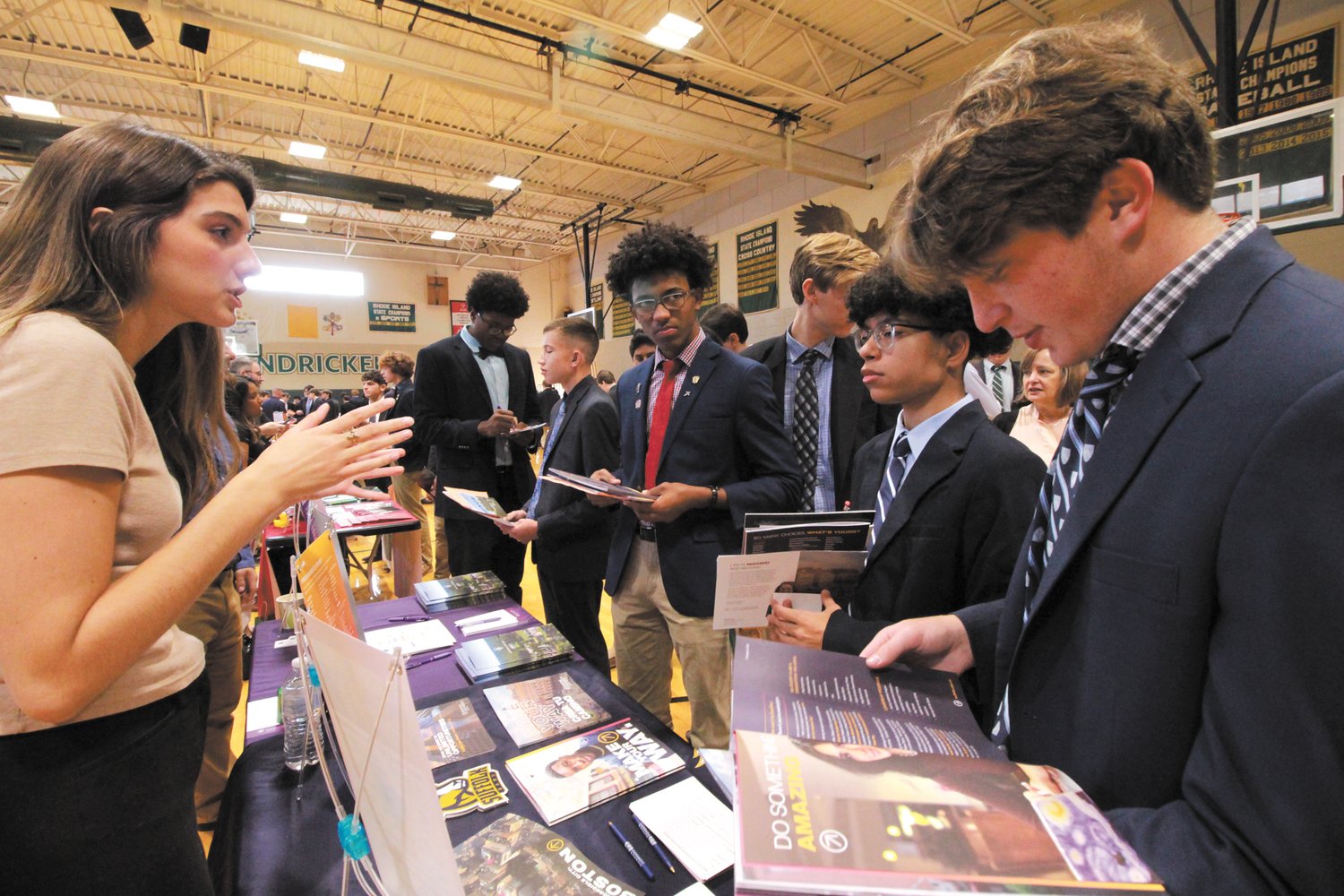 LOTS TO SAY: Students flip through brochures as they learn what Suffolk University has to offer at the college fair.