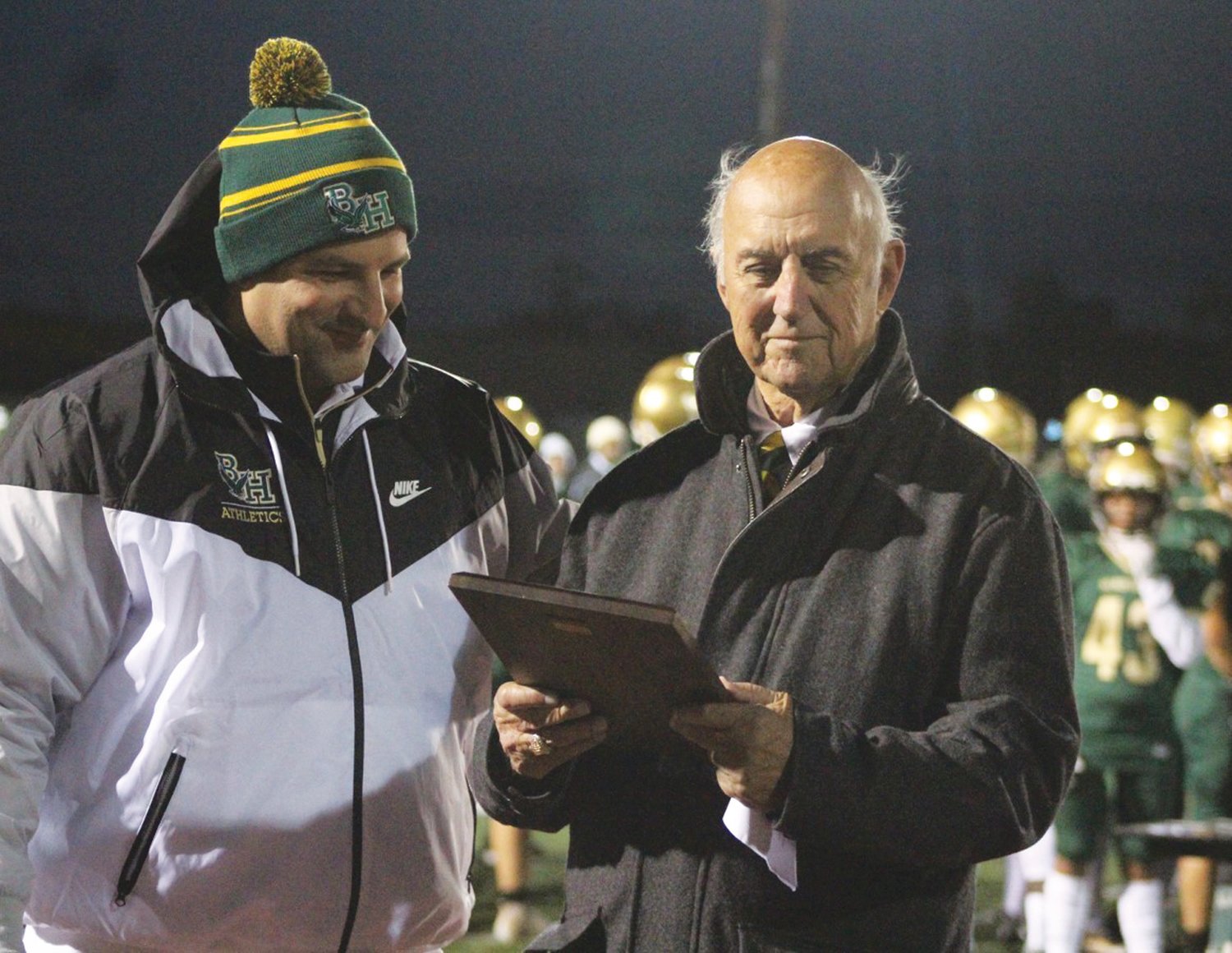 MAN OF THE HOUR: Bishop Hendricken president Mark DeCiccio presents Ed Fracassa (right) with a plaque during the ceremony to rename the football field in his honor last Friday night. (Photo by Alex Sponseller)