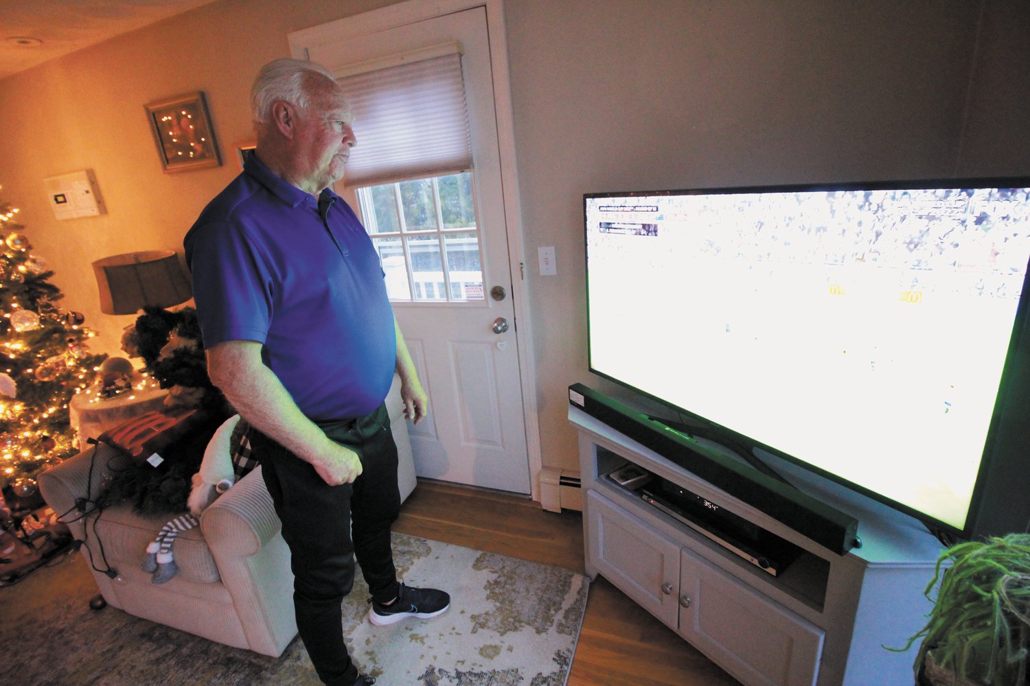 GLUED TO THE TELLIE: Mick Rooney watches the World Cup last week in his home, where he has viewed every game of the tournament. (Warwick Beacon Photo)
