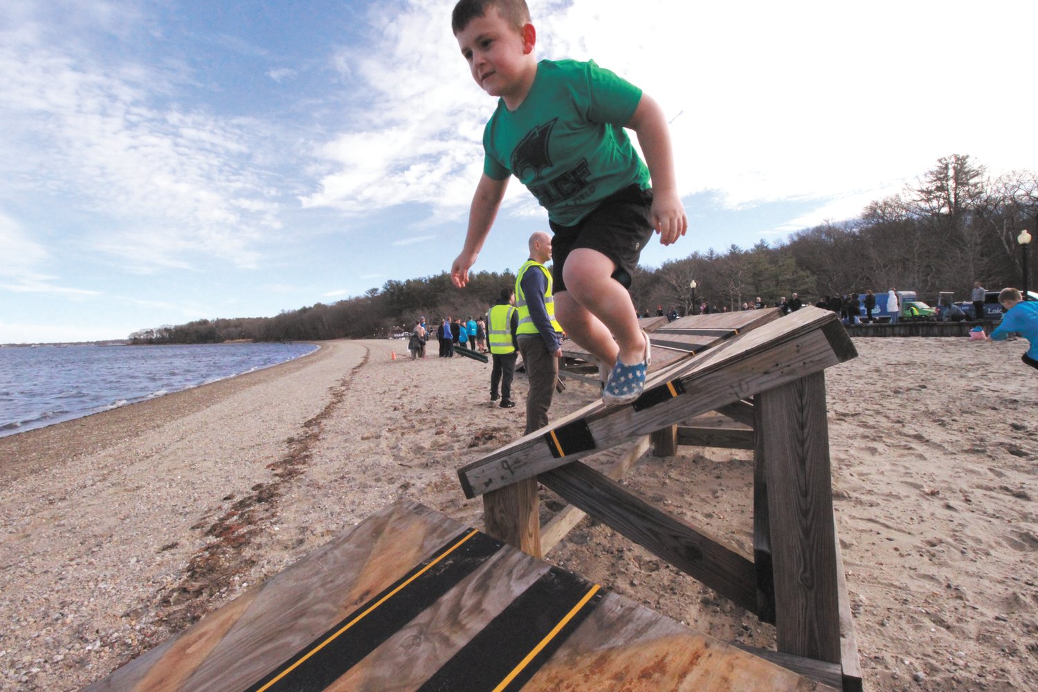 LEAP BEFORE THE DIVE: Owen Powell clears the final obstacle before charging into the bay.