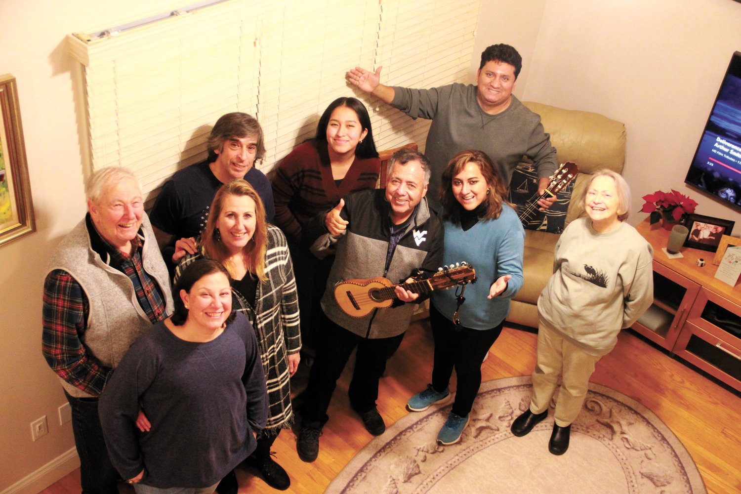 A CHORUS: Forty years after spending a year in Warwick as a member of the Rotary Club student exchange program, Alejandro Camara and members of his family returned to see his host families. Here they are pictured in the home of Gordon and Marilyn Wilmot after a sing along of popular Spanish and American songs: Gordon Wilmot, his daughters Sarah Perrone and Sue Cabeceiras, Sue’s husband Kevin, Carola, Alejandro’s granddaughter, Alejandro, his daughter Lucero, his son Cesar and Marilyn Wilmot. (Warwick Beacon photo)