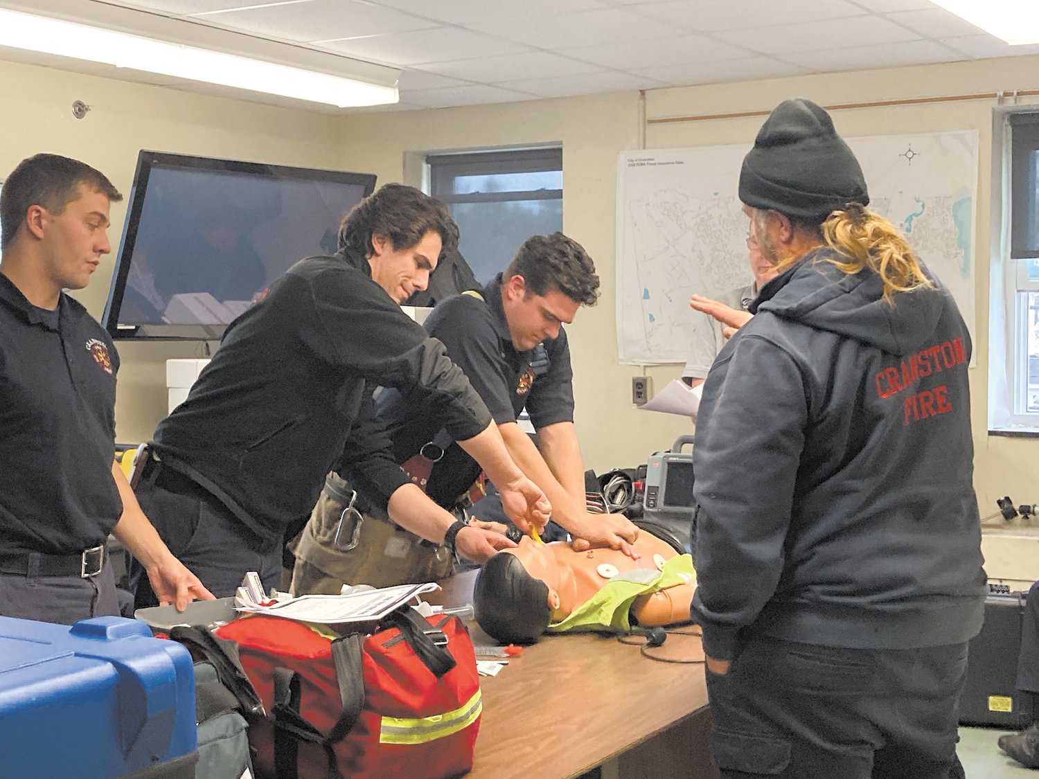 PROPOSED SCENARIO: A CFD rescue crew gives chest compressions to a special mannequin used for CPR training. After completing the proposed scenario, the crew reflects on what went well and what could have been done better. (Herald photo)