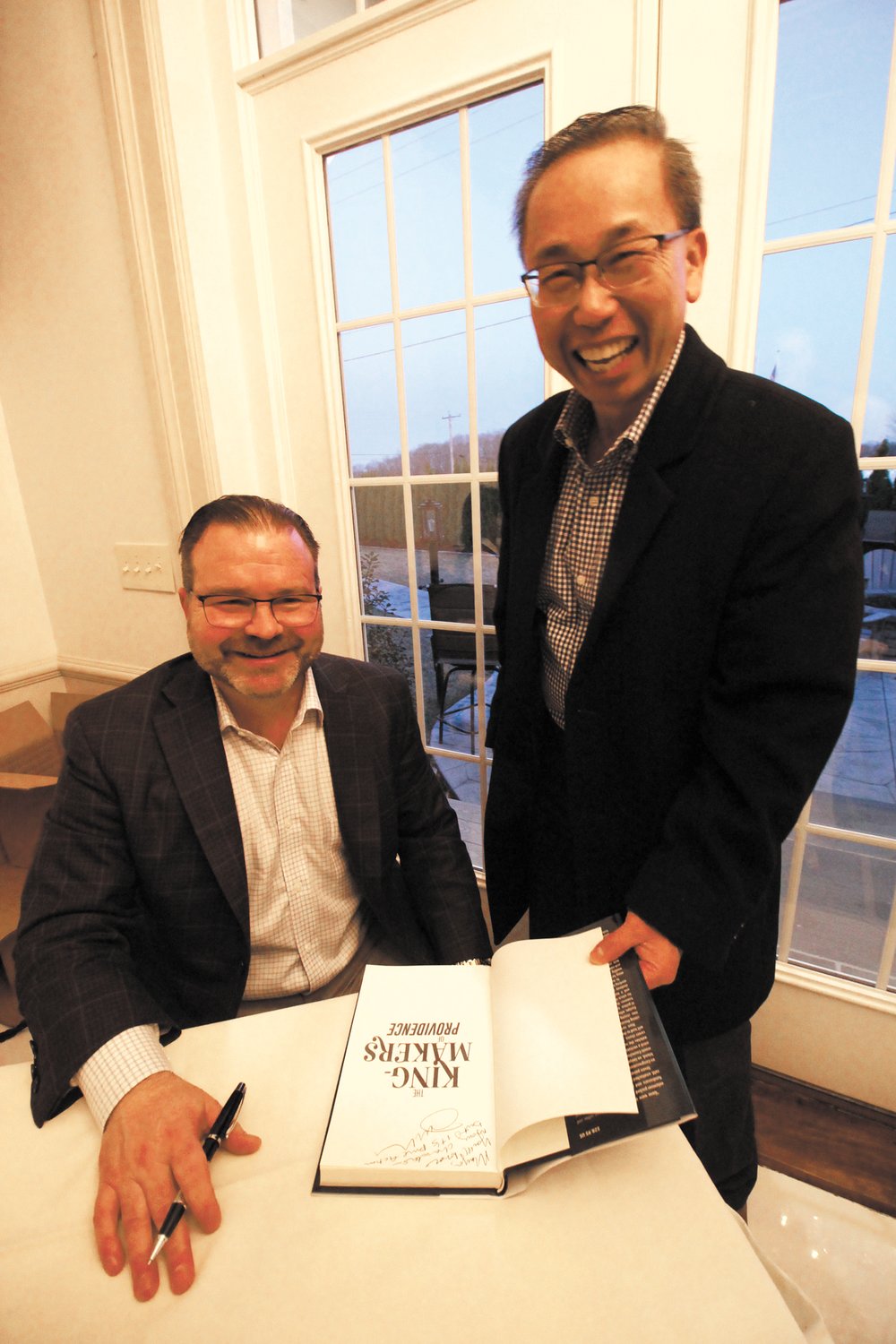 IS HE IN THE BOOK? Former Cranston Mayor Allan Fung didn’t really think he is a character in John Houle’s recently released The King-Makers of Providence, but the question evoked laughs last Wednesday at the novel’s book signing at the Alpine Country Club in Cranston. While Houle, who runs his own advertising and public relations firm maintains all the characters in the book are fictional, it’s not hard to imagine some were patterned from some of the state’s colorful politicians. Houle grew up in the Gaspee section of Warwick. He said there have been talks of making a movie based on the book.  Houle is already working on his second novel.  (Warwick Beacon  photo)