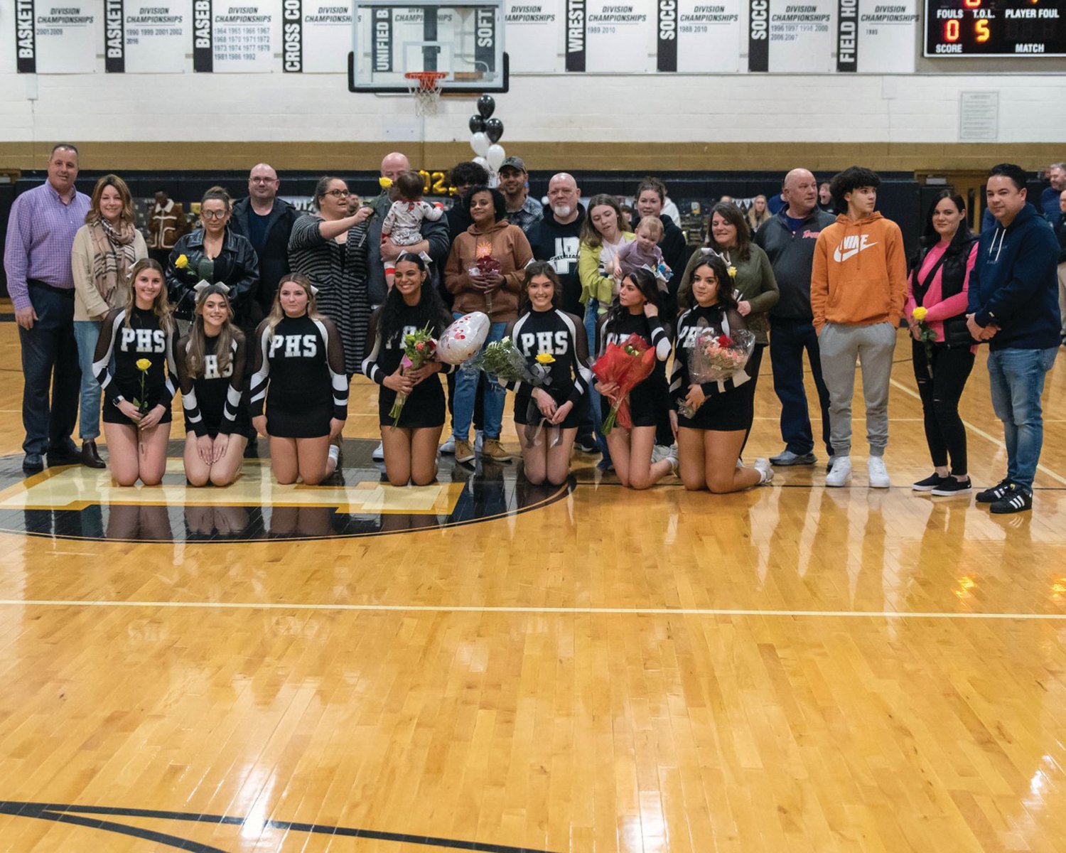 SENIOR NIGHT: Members of the Pilgrim cheerleading team gather at center court with their families during the team’s Senior Night celebration on Tuesday evening.