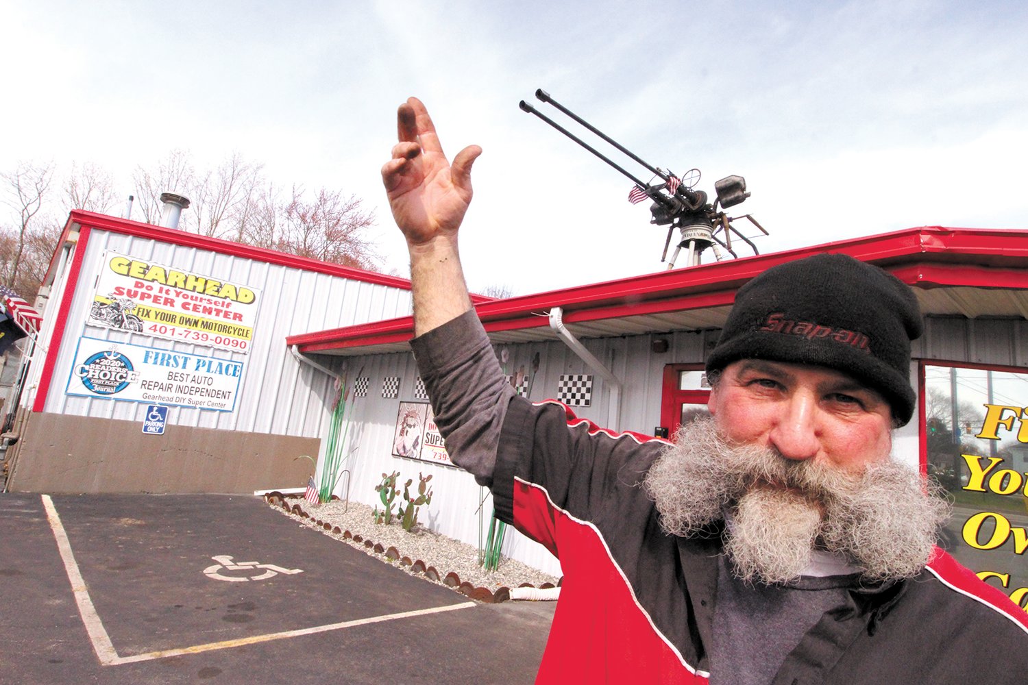 VLOTS OF QUESTIONS: Ron Long who owns Gearhead DIY Super Center with his wife Cheryl is accustomed to being questioned about the replica anti-aircraft emplacement guarding the roof of the shop.  (Warwick Beacon photo)