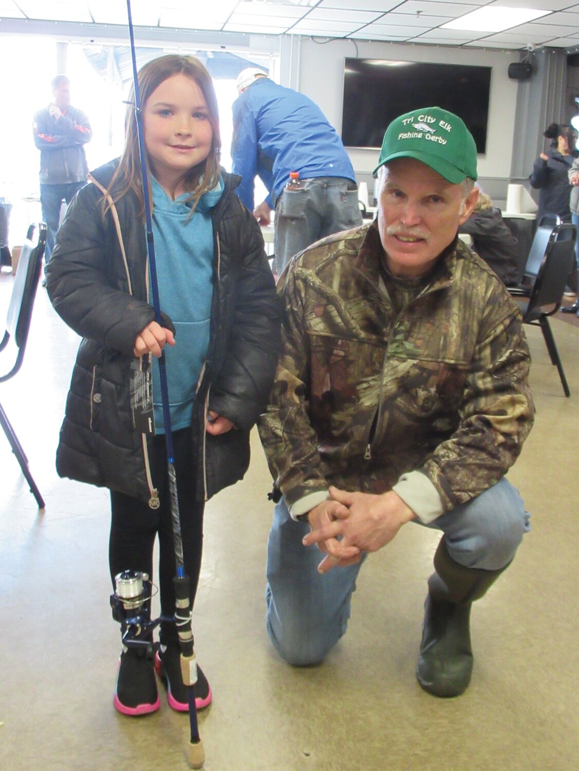 PERFECT PRIZE: Dave Brown, who chairs the trout division of the Tri-City Elks Kids Fishing Derby, presents the first-place prize to Olivia Smith, 8, for her 16.3-inch catch.