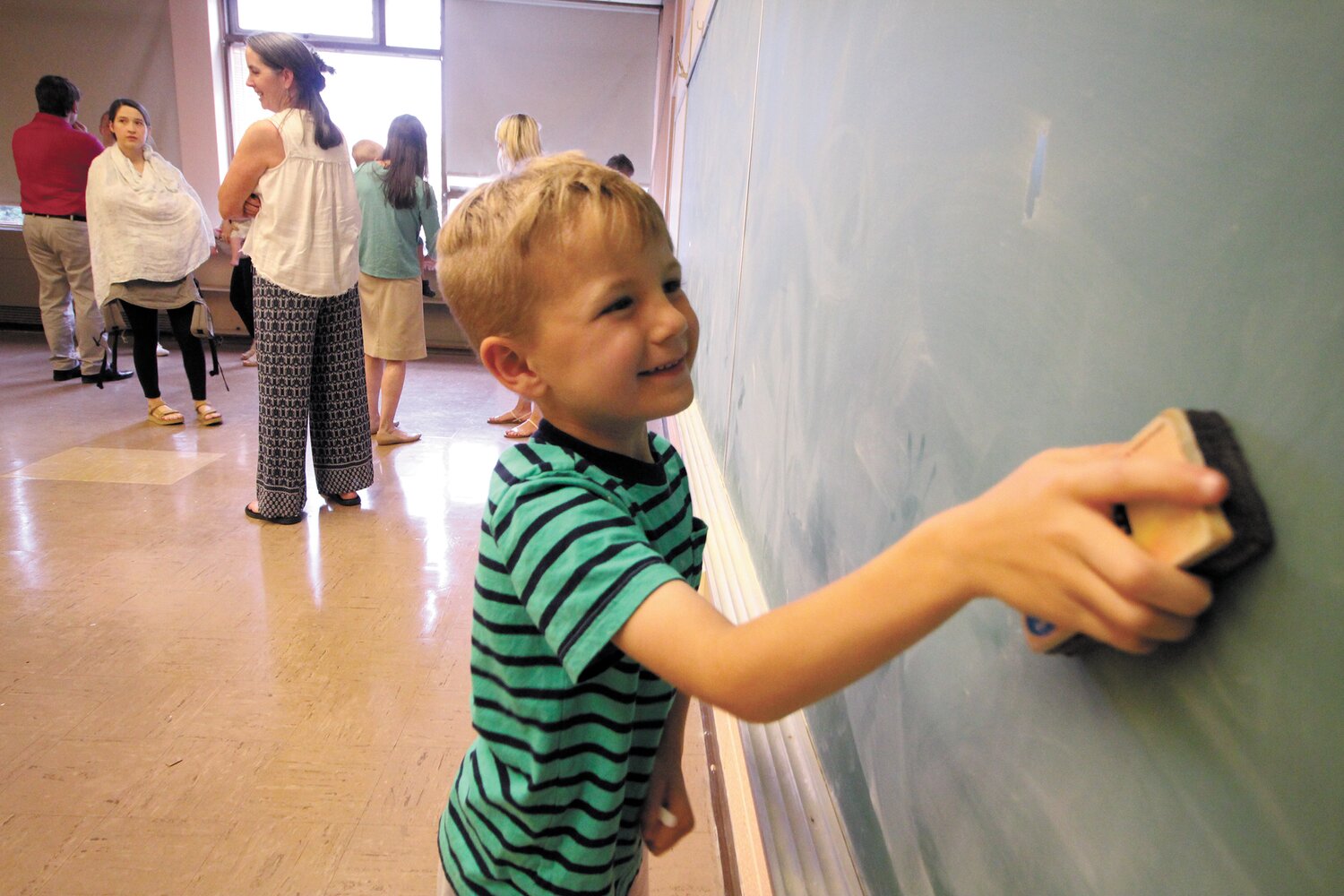 A CLEAN SWEEP: Alian Primeau cleans a board in one of the school’s classrooms.