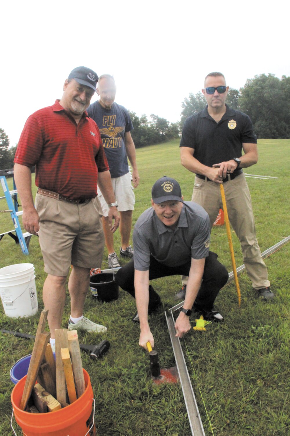 ERECTING THE WALL: Rotarians from across the state helped assemble the wall at Rocky Point Friday morning. Here, Oliver Brady, president of the Warwick Rotary Club, prepares the track for wall sections that Rotarians joining  him will be lifted into place . (Warwick Beacon photos)