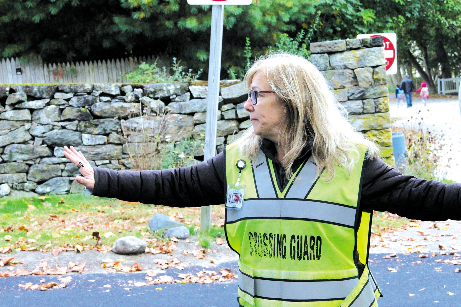 KEEPING THEM SAFE:   Crossing guard Julie Peters directs traffic on Rocky Point Avenue with an ever mindful eye on safety.