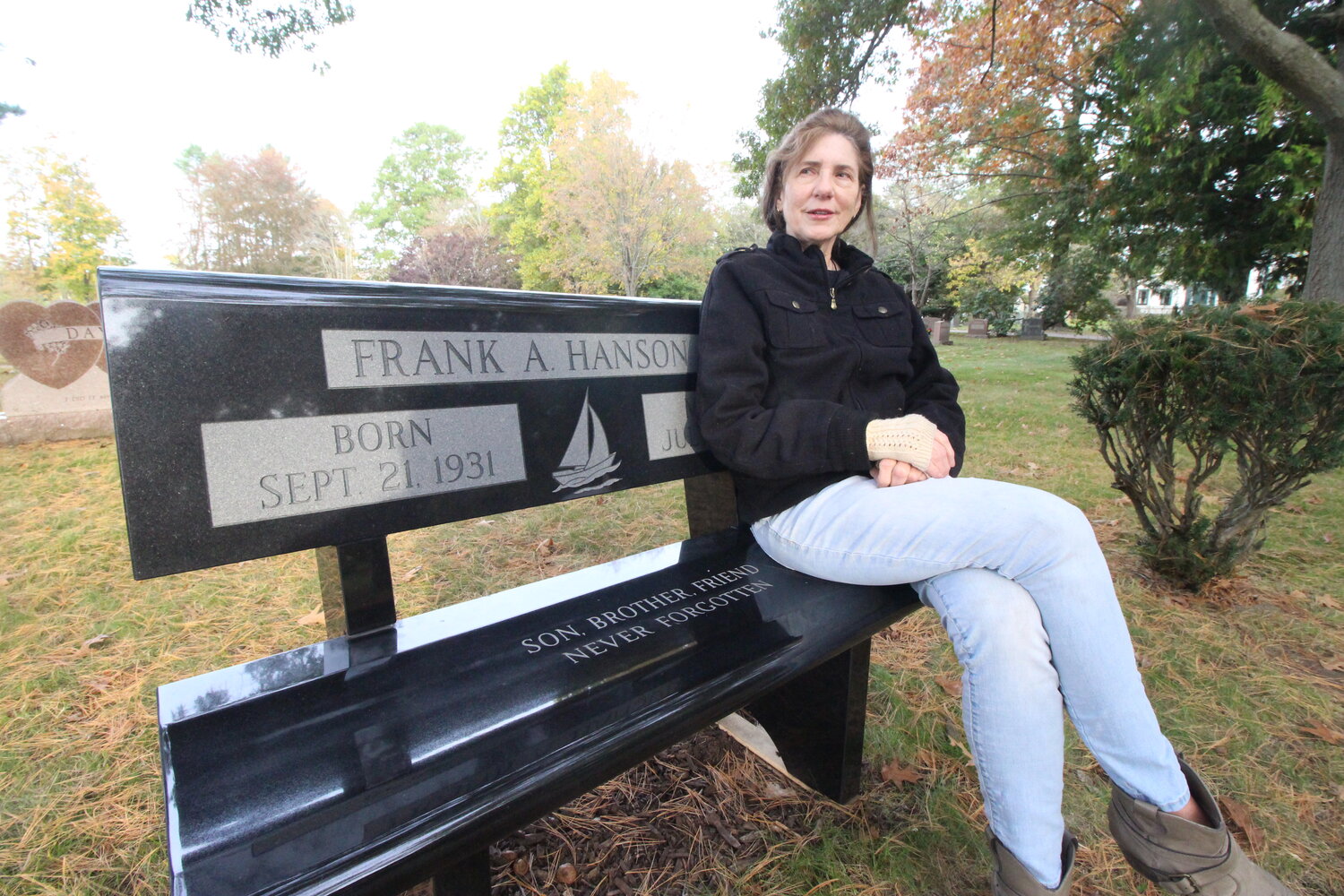 IN MEMORY OF FRANK HANSON JR.: Gloria Coppola who retired as a major crimes investigator from the  New York State Police (NYSP) Bureau of Criminal Investigation has hopes of finding remains of Frank Hanson who was last seen on July 12, 1947. She sits on a bench she bought and is across from the grave stone of Frank’s parents at Pawtuxet Memorial Cemetery in Warwick. (Cranston Herald photos)