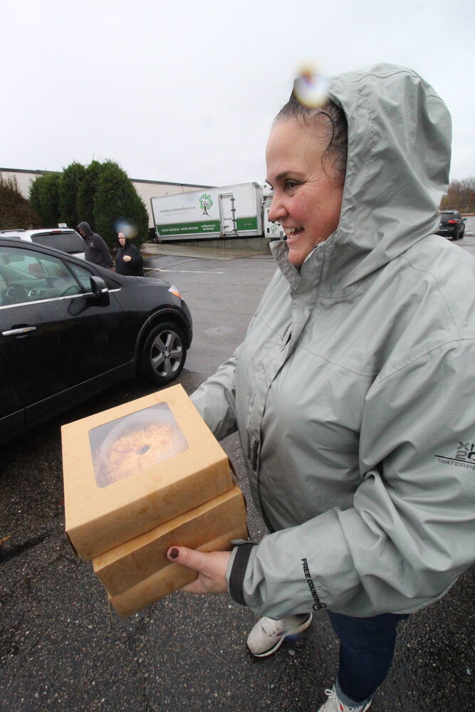 PIE TO GO: Abbie Groves rushes to deliver a pie at Saturday’s Westbay pickup. She was wearing a rain coat until she loaned it to a volunteer.
