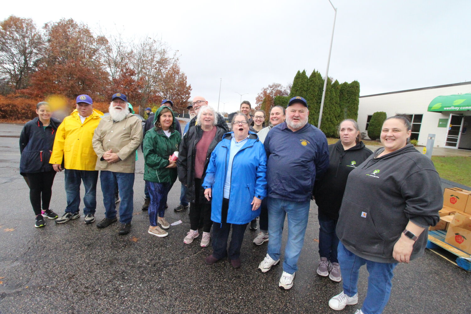 TEAMING UP TO HELP: In a break from the action members of the Scituate Lions Club gather with Westbay staff and volunteers for a photo.